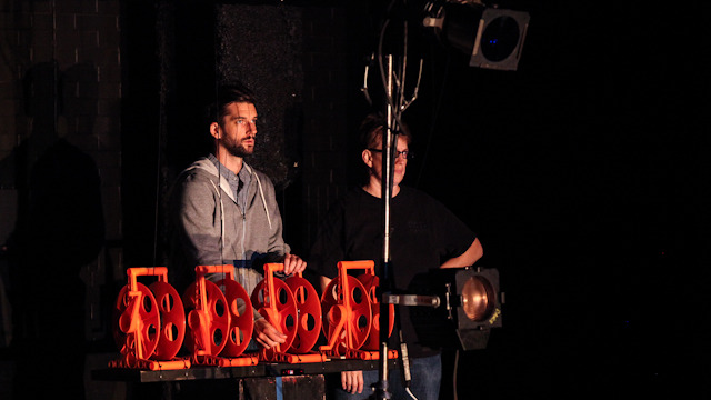 Wirsing and Eckwall raise and lower fish skin lanterns back stage at <i>Niicugni (Listen)</i> rehearsal.