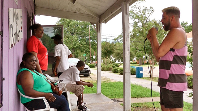 Miguel Gutierrez sings outside a barber shop