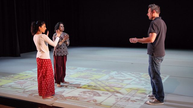 Ranee and Aparna Ramaswamy discuss the projection of the game board with FSU designer Zach Cramer