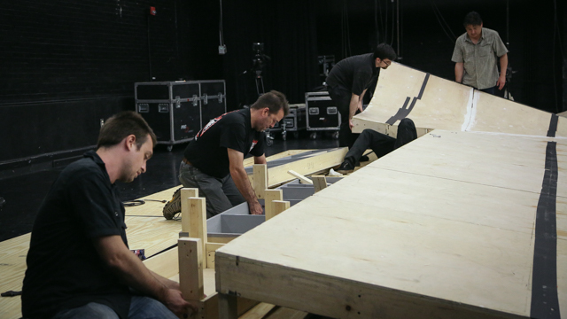 The production crew re-assembles the ramp.