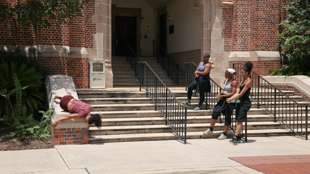 Bauman engages in process on the steps of the Katherine W. Montgomery Building with Hailes, Mozie,<br>and Stiggers observe.