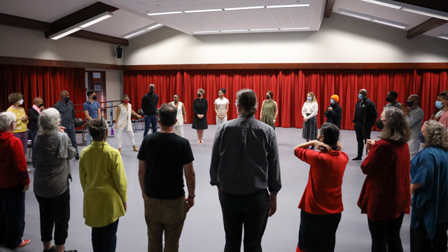 All session attendees stand in a circle at the end of the sharing